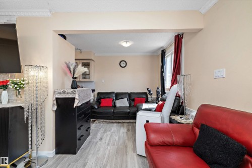 Living area with light wood-type flooring, ornamental molding, and a textured ceiling - 127 Cornell Court, Edmonton, AB - Indoor