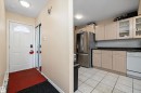 Kitchen featuring glass insert cabinets, stainless steel fridge, white dishwasher, a textured ceiling, and light tile patterned flooring - 127 Cornell Court, Edmonton, AB  - Indoor Photo Showing Kitchen 