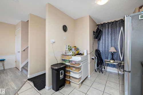 Interior space with freestanding refrigerator, light tile patterned flooring, and a textured ceiling - 127 Cornell Court, Edmonton, AB - Indoor