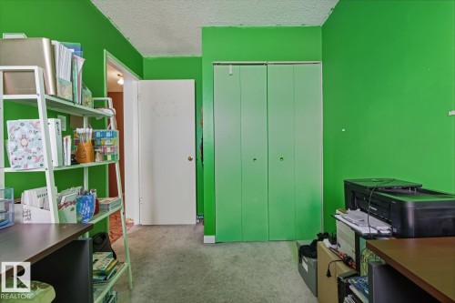 Recreation room featuring a desk, light carpet, and a textured ceiling - 18307 66 Avenue, Edmonton, AB - Indoor