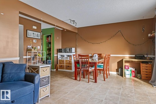 Dining room with track lighting, a textured ceiling, and light tile patterned floors - 18307 66 Avenue, Edmonton, AB - Indoor
