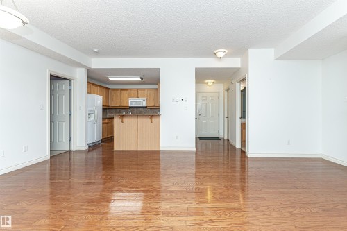 Unfurnished living room with a textured ceiling and dark wood finished floors - 112 260 Sturgeon Road, St. Albert, AB - Indoor Photo Showing Kitchen