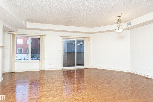 Empty room with a textured ceiling and light wood finished floors - 112 260 Sturgeon Road, St. Albert, AB - Indoor