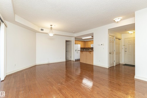 Unfurnished living room featuring light wood-style flooring and a textured ceiling - 112 260 Sturgeon Road, St. Albert, AB - Indoor Photo Showing Other Room
