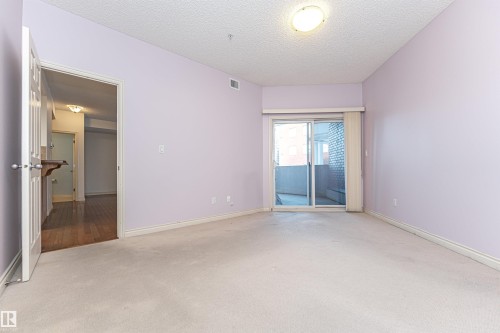 Carpeted empty room featuring a textured ceiling and baseboards - 112 260 Sturgeon Road, St. Albert, AB - Indoor Photo Showing Other Room