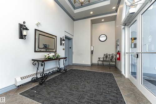 Foyer entrance with a baseboard radiator, ornamental molding, a high ceiling, recessed lighting, and elevator - 112 260 Sturgeon Road, St. Albert, AB - Indoor Photo Showing Other Room