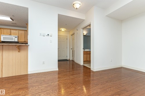 Unfurnished living room featuring dark wood-style flooring and a textured ceiling - 112 260 Sturgeon Road, St. Albert, AB - Indoor Photo Showing Other Room