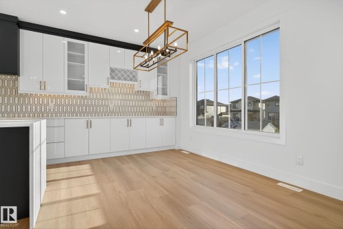 Unfurnished dining area with a chandelier and light wood-style flooring - 3508 6 Street, Edmonton, AB - Indoor