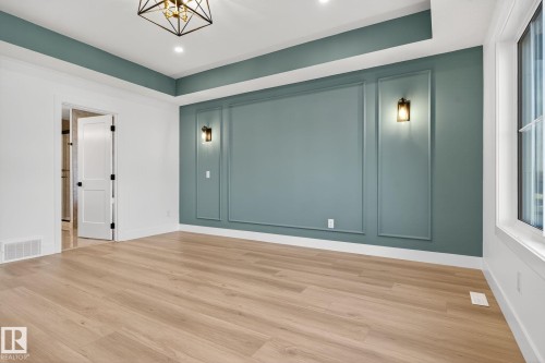 Unfurnished room with a decorative wall, wood finished floors, and a raised ceiling - 3508 6 Street, Edmonton, AB - Indoor Photo Showing Other Room