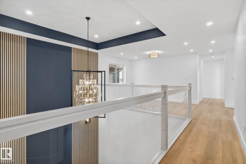 Hallway featuring a chandelier, light wood finished floors, and an upstairs landing - 3508 6 Street, Edmonton, AB - Indoor Photo Showing Other Room