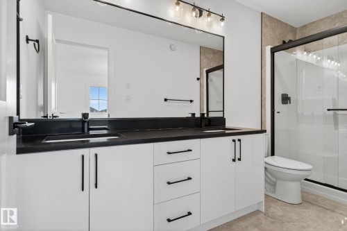 Full bathroom featuring a shower stall, double vanity, and light tile patterned flooring - 3508 6 Street, Edmonton, AB - Indoor Photo Showing Bathroom