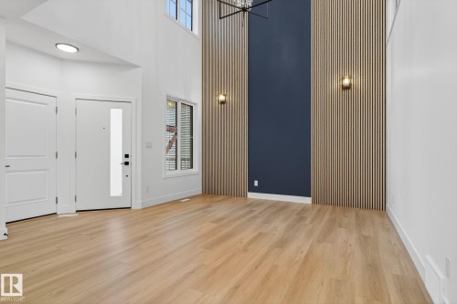 Foyer entrance with a high ceiling, light wood-style flooring, and hanging lights - 3508 6 Street, Edmonton, AB - Indoor Photo Showing Other Room