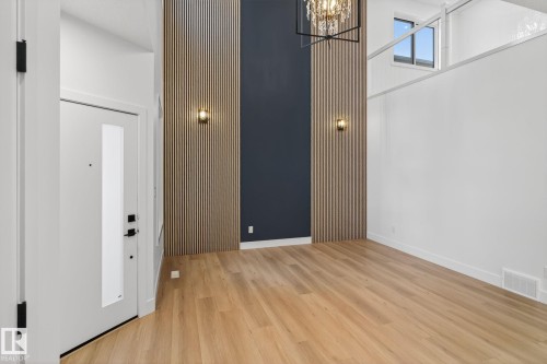 Foyer entrance featuring a high ceiling, suspended lighting, and wood finished floors - 3508 6 Street, Edmonton, AB - Indoor Photo Showing Other Room