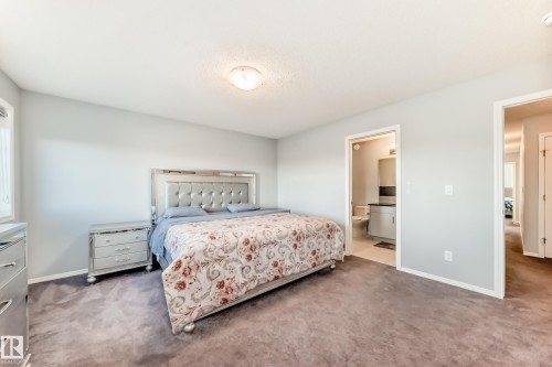 Bedroom with carpet flooring, a textured ceiling, and connected bathroom - 1002 Stillwater Boulevard, Edmonton, AB - Indoor Photo Showing Bedroom