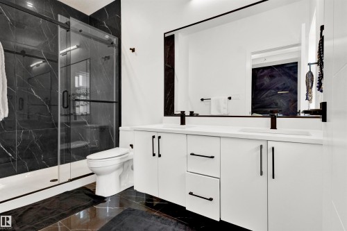 Bathroom featuring double vanity, a marble finish shower, and dark marble finish flooring - 9559 85 Street, Edmonton, AB - Indoor Photo Showing Bathroom