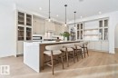 Kitchen with glass insert cabinets, a breakfast bar, hanging light fixtures, light wood-type flooring, and recessed lighting - 58 Redpoll Wynd, St. Albert, AB  - Indoor Photo Showing Other Room 
