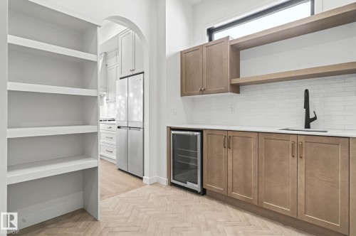 Bar with open shelves, parquet floors, wine cooler, freestanding refrigerator, and brown cabinets - 58 Redpoll Wynd, St. Albert, AB - Indoor