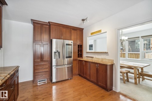 Kitchen with stainless steel fridge, light wood-type flooring, and light stone countertops - 14018 100 Avenue, Edmonton, AB - Indoor Photo Showing Kitchen With Stainless Steel Kitchen