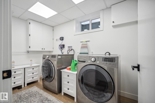 Laundry area with a drop ceiling, light wood-type flooring, and independent washer and dryer - 14018 100 Avenue, Edmonton, AB - Indoor Photo Showing Laundry Room