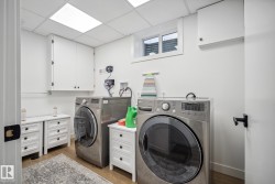 Laundry area with a drop ceiling, light wood-type flooring, and independent washer and dryer - 