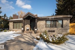 View of front facade featuring a chimney and stone siding - 