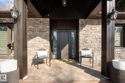 Doorway to property featuring stone siding and a porch - 