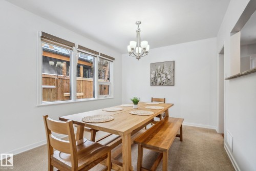 Dining room with suspended lighting and light colored carpet - 14018 100 Avenue, Edmonton, AB - Indoor Photo Showing Dining Room