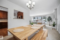 Dining room with suspended lighting and light colored carpet - 