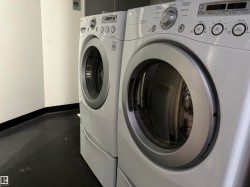 Laundry room featuring washing machine and dryer and finished concrete floors - 