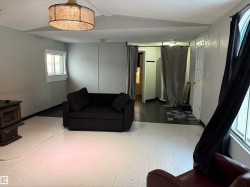 Living room featuring a wood stove and a textured ceiling - 