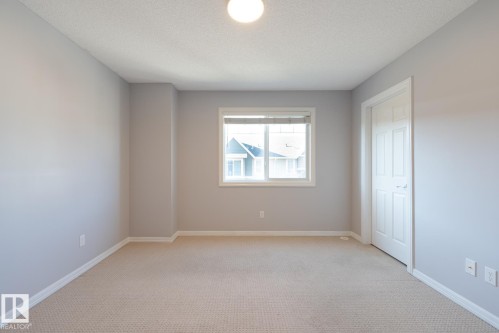 Unfurnished room featuring light carpet and a textured ceiling - 103 655 Tamarack Road, Edmonton, AB - Indoor Photo Showing Other Room