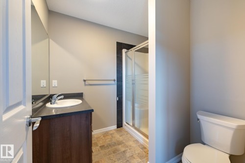 Full bath featuring a shower stall, vanity, and stone finish flooring - 103 655 Tamarack Road, Edmonton, AB - Indoor Photo Showing Bathroom