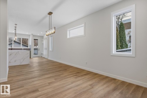 Unfurnished dining area with healthy amount of natural light, light wood finished floors, and suspended lighting - 9627 152 Street Nw, Edmonton, AB - Indoor Photo Showing Other Room