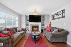 Living area featuring a tile fireplace, hardwood / wood-style flooring, built in features, and a textured ceiling - 