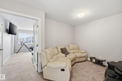 Living area with a textured ceiling and carpet flooring - 