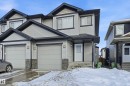 View of front of property with a garage, stone siding, and board and batten siding - 5978 167C Avenue, Edmonton, AB  - Outdoor With Facade 