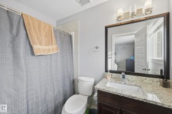 Bathroom with vanity, curtained shower, and a textured ceiling - 