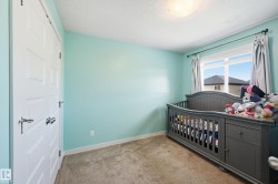 Bedroom featuring light carpet and a textured ceiling - 