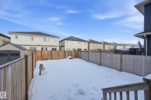 Yard covered in snow featuring a residential view, a fenced backyard, and a storage unit - 5978 167C Avenue, Edmonton, AB - Outdoor With Exterior