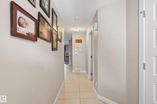 Hallway featuring light tile patterned floors and a textured ceiling - 5978 167C Avenue, Edmonton, AB - Indoor Photo Showing Other Room