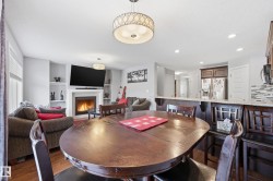 Dining space with wood finished floors, a lit fireplace, recessed lighting, and built in features - 