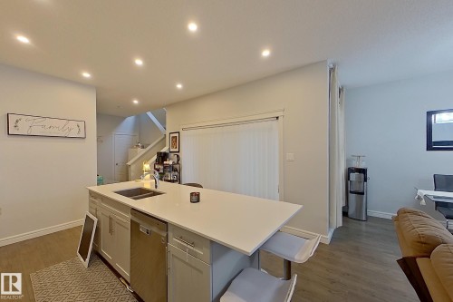 Kitchen featuring recessed lighting, dishwasher, dark wood finished floors, an island with sink, and open floor plan - 4419 Kinsella Green, Edmonton, AB - Indoor