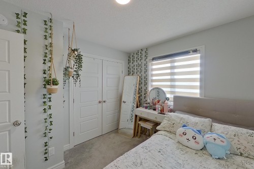 Bedroom featuring light colored carpet, a textured ceiling, and a closet - 4419 Kinsella Green, Edmonton, AB - Indoor Photo Showing Bedroom