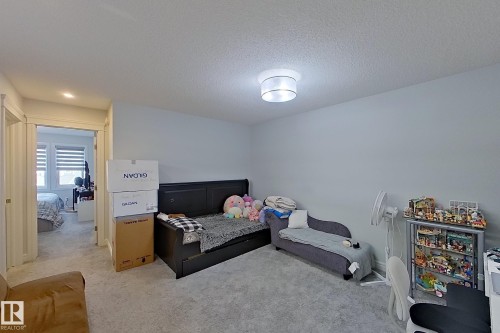 Bedroom with light colored carpet and a textured ceiling - 4419 Kinsella Green, Edmonton, AB - Indoor Photo Showing Bedroom
