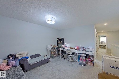 Bedroom featuring light colored carpet, a textured ceiling, and an office area - 4419 Kinsella Green, Edmonton, AB - Indoor