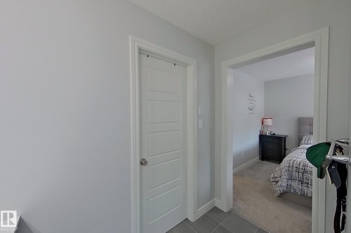 Bedroom with light carpet and a textured ceiling - 4419 Kinsella Green, Edmonton, AB - Indoor