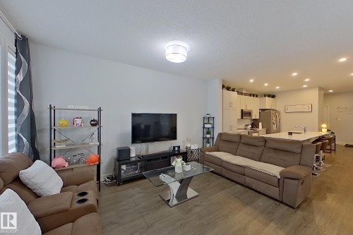 Living area featuring light wood-style flooring, recessed lighting, and a textured ceiling - 4419 Kinsella Green, Edmonton, AB - Indoor Photo Showing Living Room
