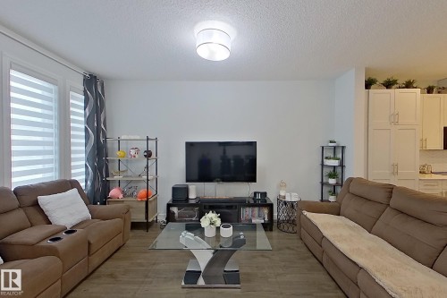 Living area with a textured ceiling and wood finished floors - 4419 Kinsella Green, Edmonton, AB - Indoor Photo Showing Living Room