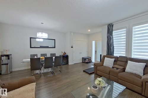 Living room with wood finished floors, a textured ceiling, and recessed lighting - 4419 Kinsella Green, Edmonton, AB - Indoor Photo Showing Living Room