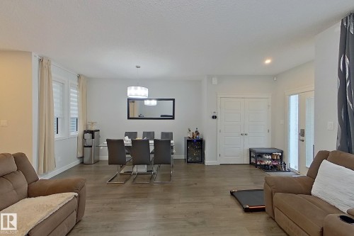 Living area featuring wood finished floors, wine cooler, and recessed lighting - 4419 Kinsella Green, Edmonton, AB - Indoor Photo Showing Living Room